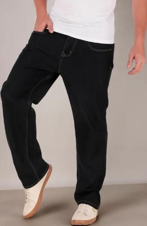 Person wearing black jeans and white sneakers on a plain background