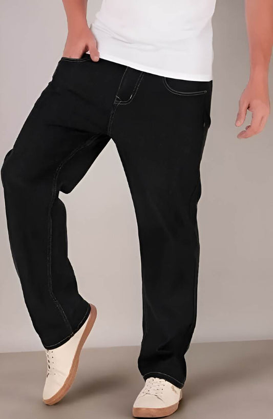 Person wearing black jeans and white sneakers on a plain background